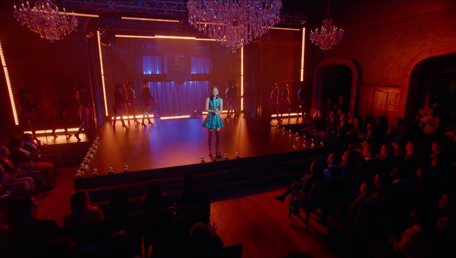 Legacies darkened ballroom with a single followspot beam crossing the room